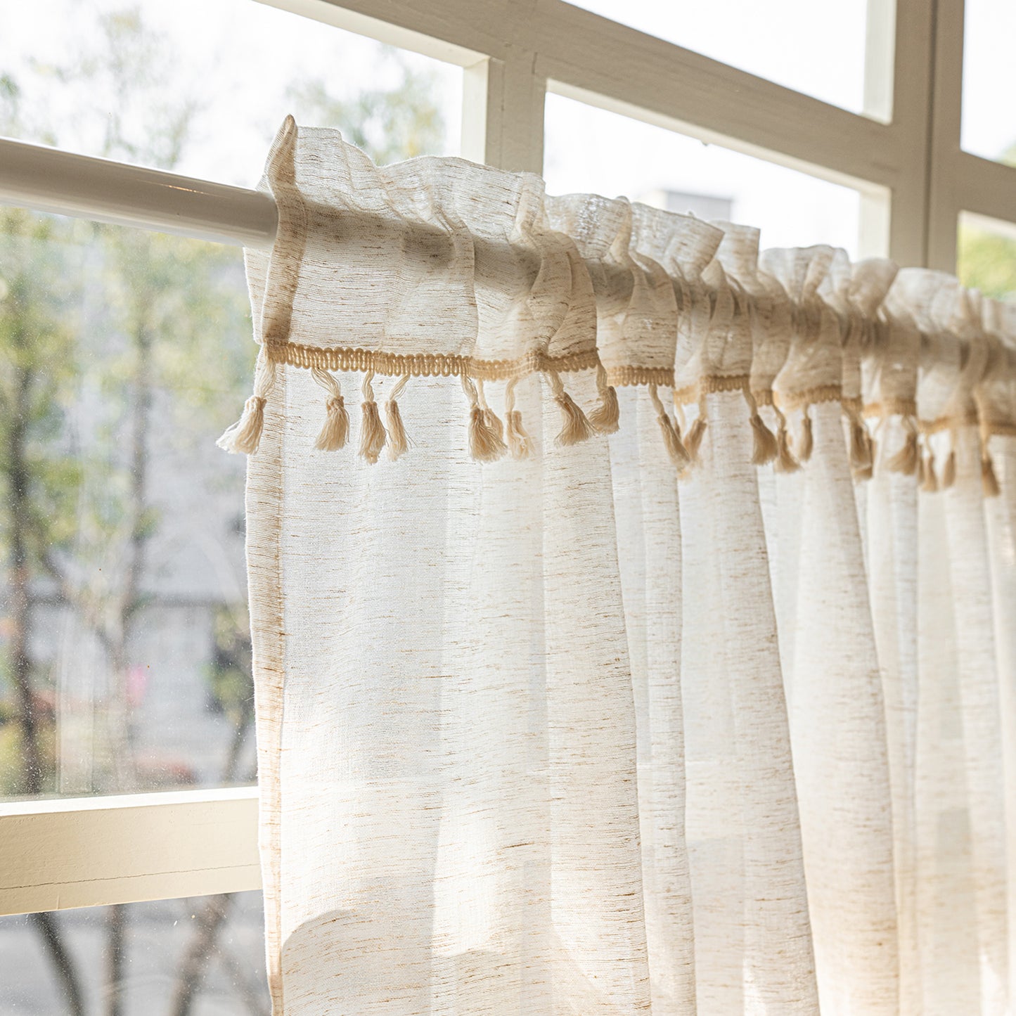 Arched cafe curtain in a linen blend with tassels in a country style